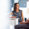 Woman, office and discussion with hr or table, company and workplace dispute with employee and serious meeting. Peace strategy, performance review and target coaching, conversation for business goal.