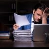 Young male employee working night in the office