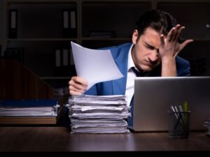 Young male employee working night in the office