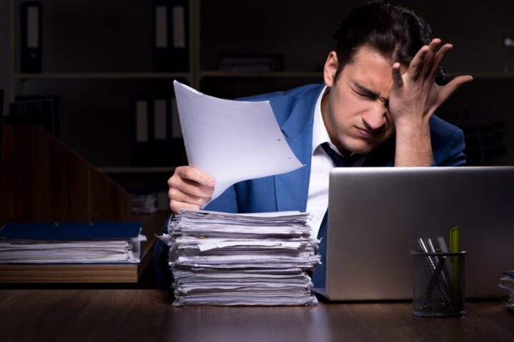 Young male employee working night in the office