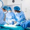Surgical team performing surgery in modern operation theater,Team of doctors concentrating on a patient during a surgery,Team of doctors working together during a surgery in operating room,