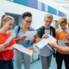 Happy students have received their exam results in high school. They are cheering and celebrating.