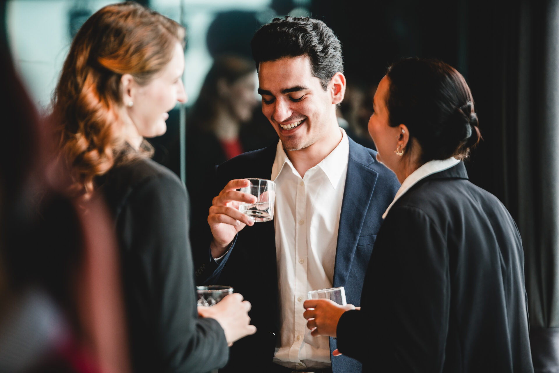 Business professionals gather after work for drinks and casual conversation. A relaxed office party moment showing teamwork, connection, and positive workplace culture in a corporate environment.