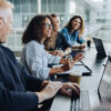 Multi-ethnic business people smiling during a meeting in conference room. Team of professionals having meeting in boardroom.
