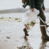 Beach cleanup volunteer carrying garbage bag for environment campaign