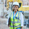 Happy engineer, construction worker or architect woman feeling proud and satisfied with career opportunity. Portrait of black building management employee or manager working on a project site.