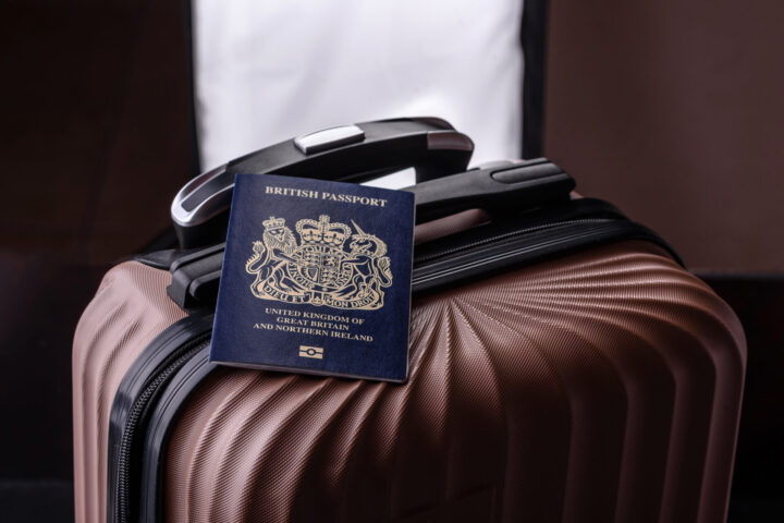 International passport of a citizen of Great Britain and Northern Ireland on a suitcase, departure from the airport, international travel